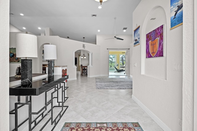 hallway with high vaulted ceiling and an inviting chandelier