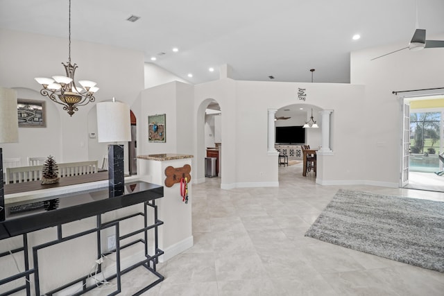 kitchen featuring light tile patterned floors, high vaulted ceiling, pendant lighting, and ceiling fan with notable chandelier