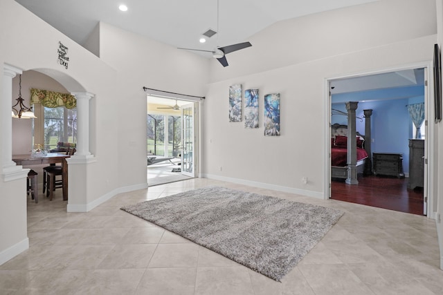 foyer with high vaulted ceiling, light tile patterned floors, ceiling fan with notable chandelier, and a wealth of natural light