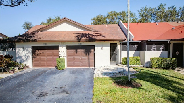 ranch-style house featuring a garage and a front lawn