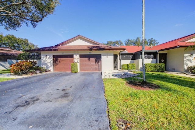 single story home with a garage and a front lawn