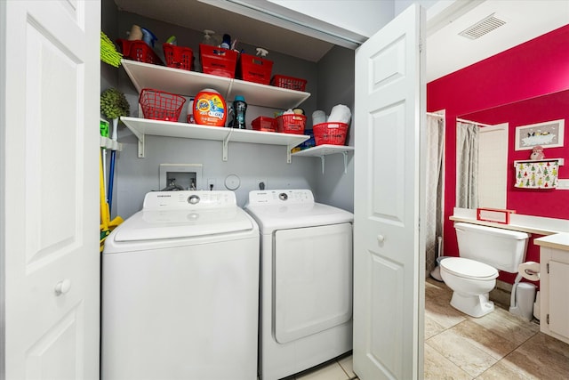 laundry room featuring separate washer and dryer and light tile patterned flooring