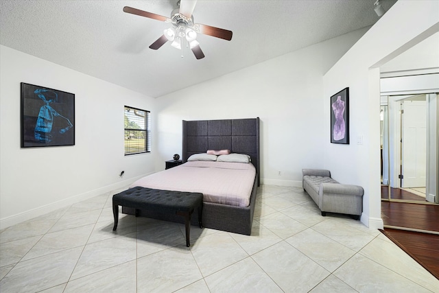 bedroom with ceiling fan, light tile patterned flooring, and lofted ceiling