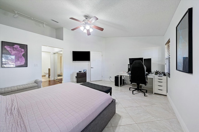 bedroom featuring a high ceiling, a textured ceiling, track lighting, and ceiling fan