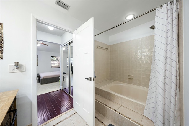 bathroom featuring tile patterned floors, vanity, ceiling fan, and shower / tub combo