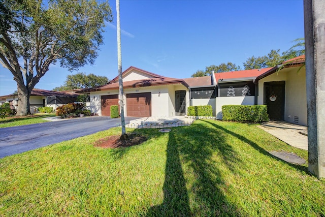 single story home featuring a garage and a front yard