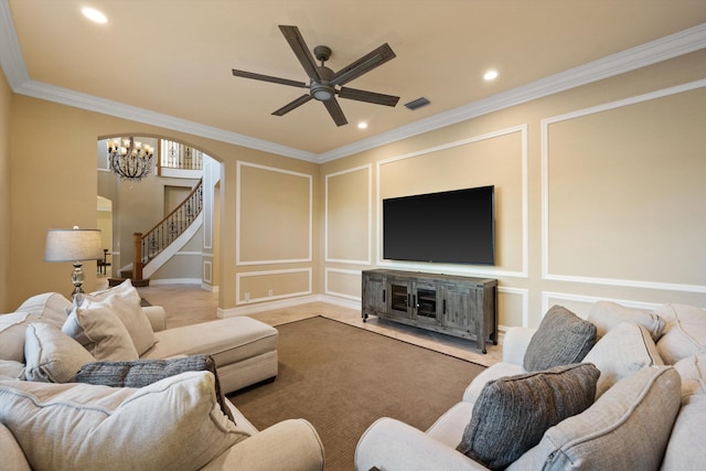 living room with crown molding, ceiling fan with notable chandelier, and carpet flooring