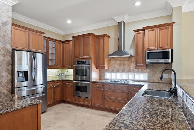 kitchen with stainless steel appliances, sink, dark stone counters, and wall chimney exhaust hood