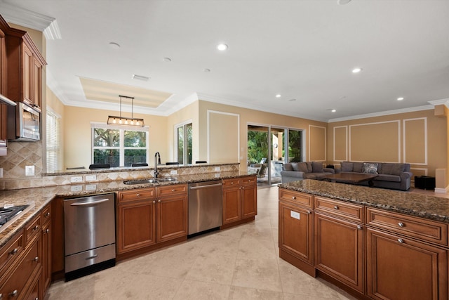 kitchen featuring sink, plenty of natural light, pendant lighting, stainless steel appliances, and decorative backsplash