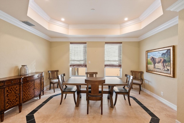 dining area with crown molding and a tray ceiling