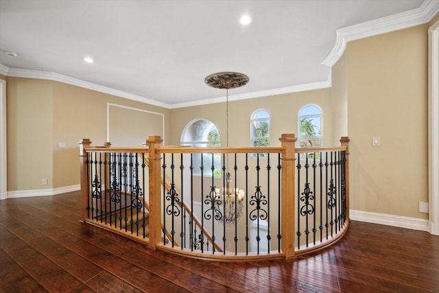 corridor featuring crown molding, dark wood-type flooring, and a chandelier