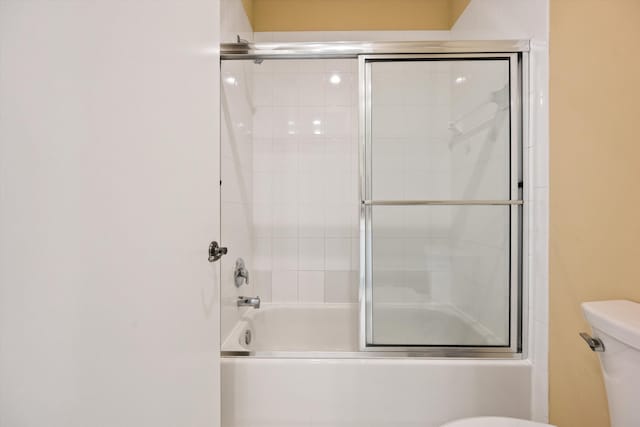 bathroom featuring enclosed tub / shower combo and toilet