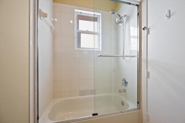 bathroom with bath / shower combo with glass door