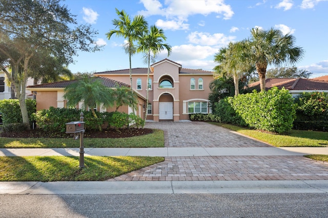 mediterranean / spanish-style home featuring a front yard