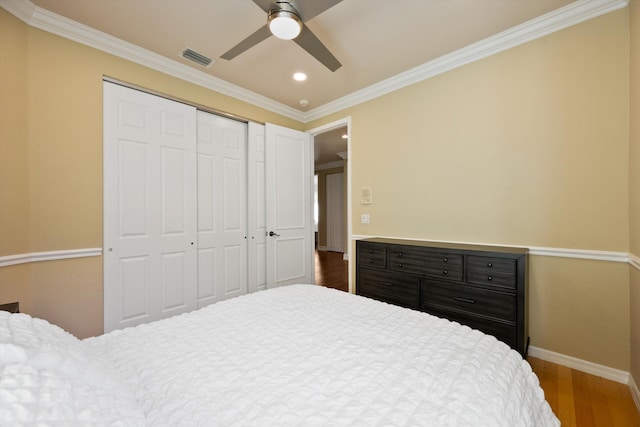 bedroom featuring crown molding, ceiling fan, dark hardwood / wood-style flooring, and a closet