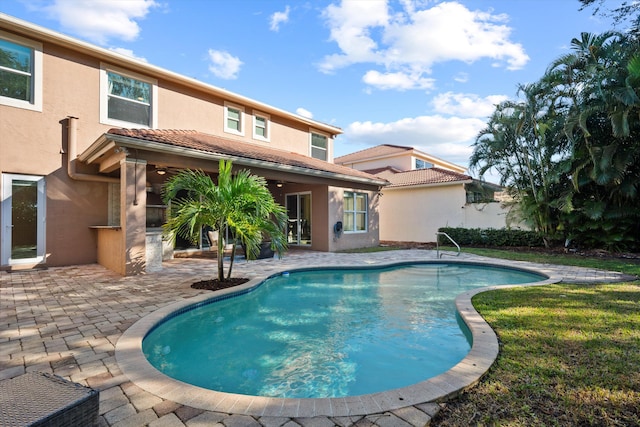 view of swimming pool featuring a yard, ceiling fan, and a patio area