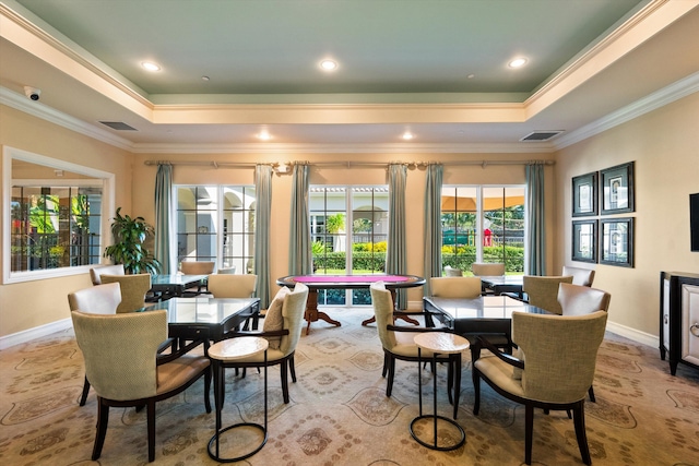 dining space with ornamental molding and a tray ceiling