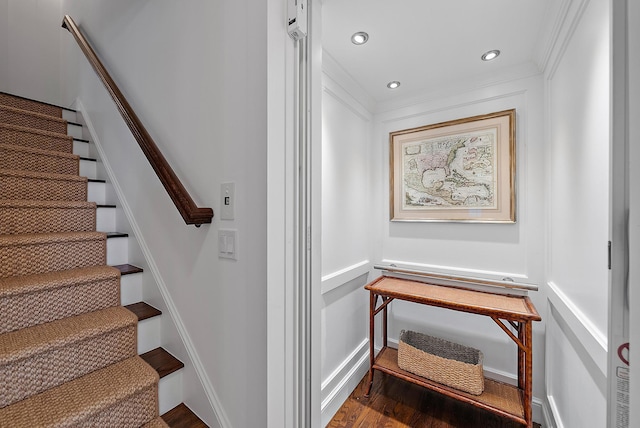 stairway with wood-type flooring, elevator, and crown molding