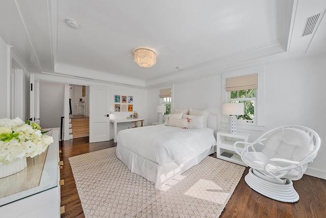 bedroom featuring a raised ceiling, crown molding, and dark wood-type flooring