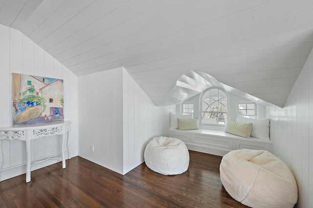 bonus room with wood walls, dark hardwood / wood-style flooring, and lofted ceiling