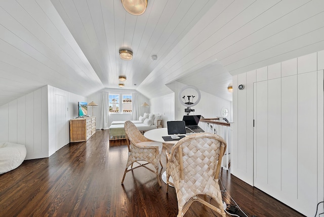 dining space with dark hardwood / wood-style floors, vaulted ceiling, and wood walls