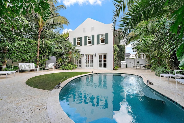 view of swimming pool with an outdoor living space, a patio area, and french doors