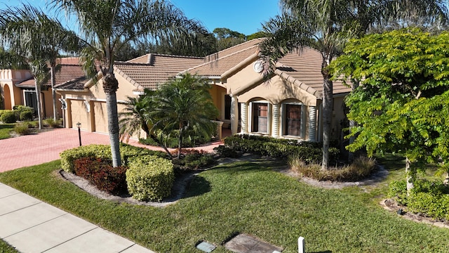 mediterranean / spanish-style house with a garage and a front yard