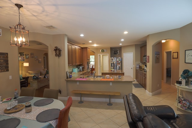 tiled dining room featuring sink and a chandelier