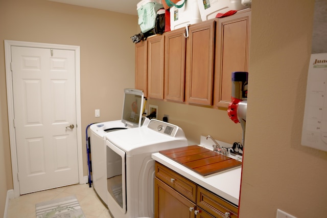 laundry room with washer and dryer, cabinets, light tile patterned floors, and sink