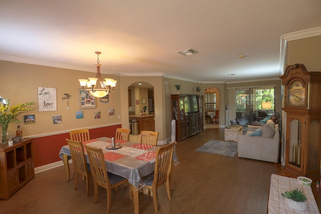 dining space with ornamental molding, dark hardwood / wood-style floors, and an inviting chandelier