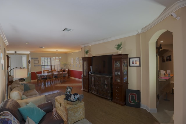 living room with hardwood / wood-style flooring, a notable chandelier, and ornamental molding