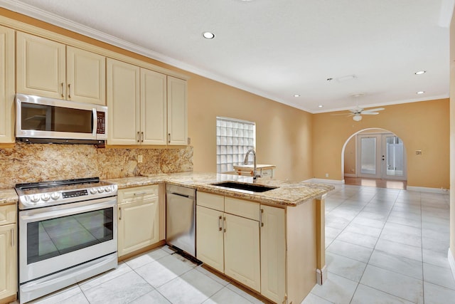 kitchen with cream cabinetry, sink, kitchen peninsula, and stainless steel appliances