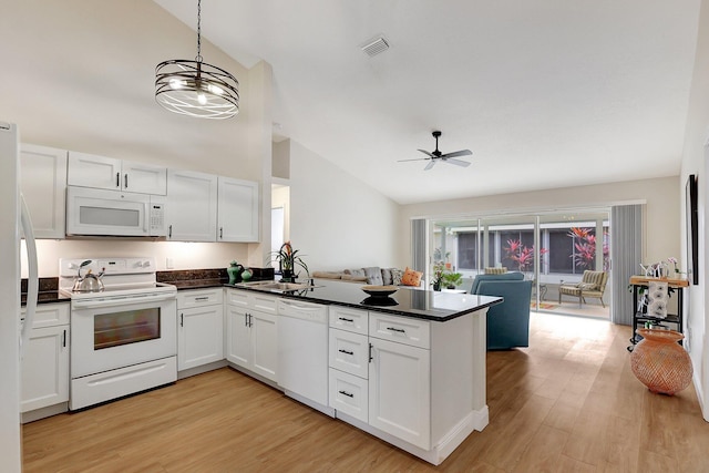 kitchen with open floor plan, white appliances, dark countertops, and white cabinets