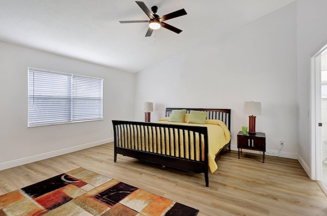 bedroom with vaulted ceiling, light wood-style flooring, baseboards, and ceiling fan