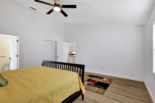 bedroom with ensuite bathroom, ceiling fan, high vaulted ceiling, wood finished floors, and baseboards