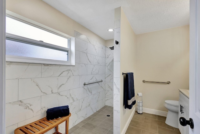 full bath with toilet, a textured ceiling, vanity, a walk in shower, and baseboards