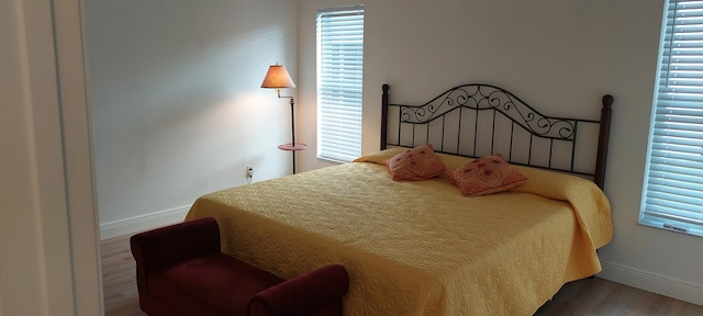 bedroom featuring baseboards and wood finished floors