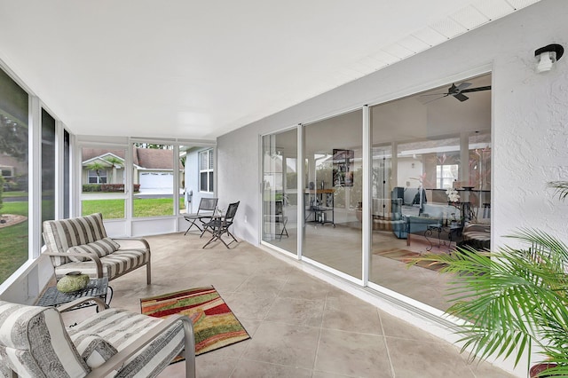 sunroom / solarium featuring a healthy amount of sunlight and ceiling fan