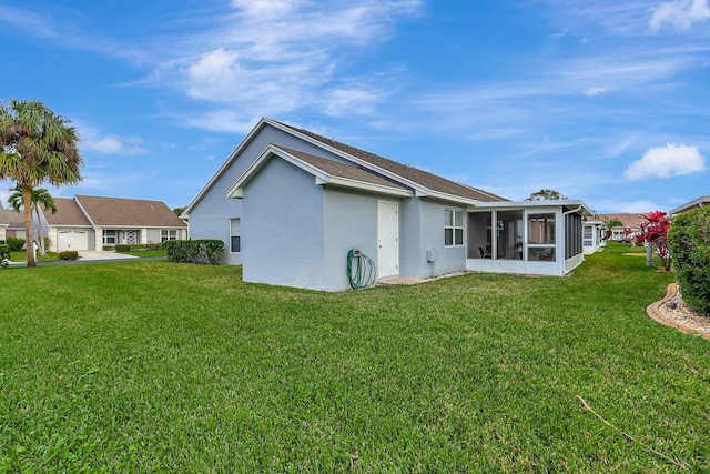 rear view of property with a residential view, a sunroom, and a yard