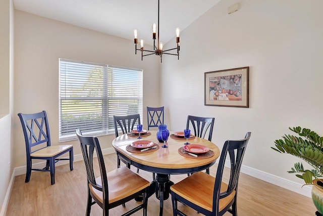 dining space with a chandelier, light wood finished floors, and baseboards