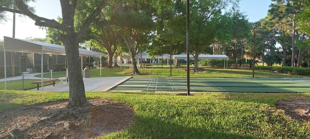 view of property's community with shuffleboard and a lawn