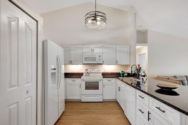 kitchen featuring white appliances, white cabinets, a sink, and decorative light fixtures