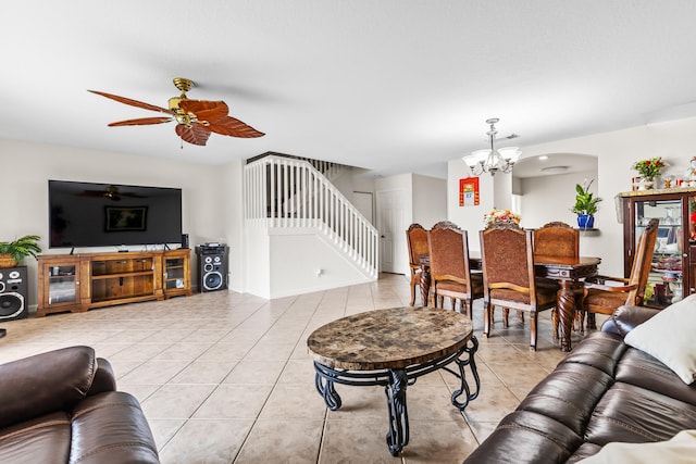 living room featuring light tile patterned flooring and ceiling fan with notable chandelier