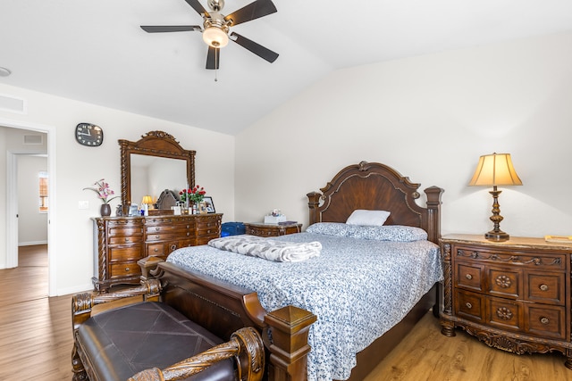 bedroom with ceiling fan, vaulted ceiling, and light wood-type flooring