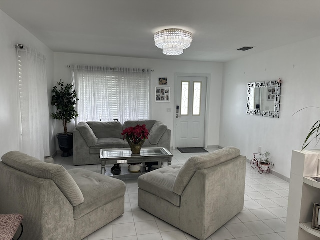 living room with light tile patterned floors and an inviting chandelier