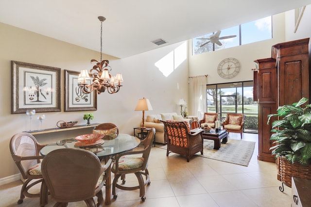 dining space featuring a high ceiling and ceiling fan with notable chandelier