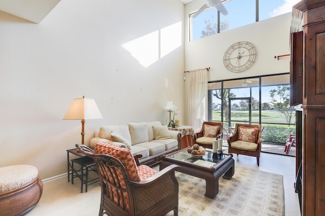 living room featuring ceiling fan and a towering ceiling