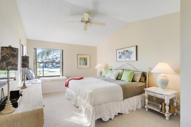 bedroom featuring a textured ceiling, ceiling fan, light carpet, and vaulted ceiling