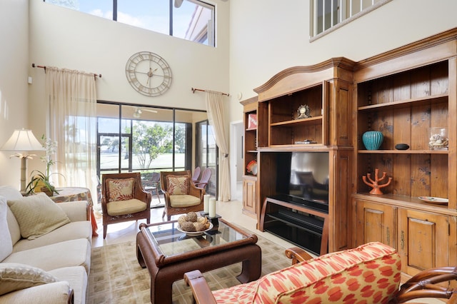 living room featuring light tile patterned flooring and a towering ceiling