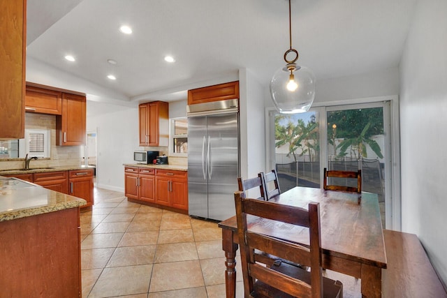 kitchen featuring sink, pendant lighting, decorative backsplash, light tile patterned floors, and appliances with stainless steel finishes